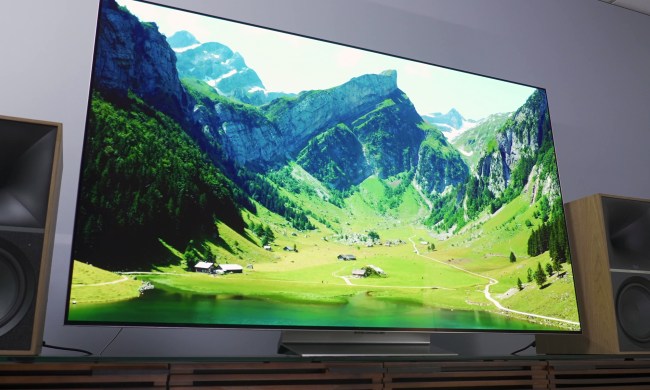 The LG G3 OLED TV on a stand, showing a mountain scene on the screen.